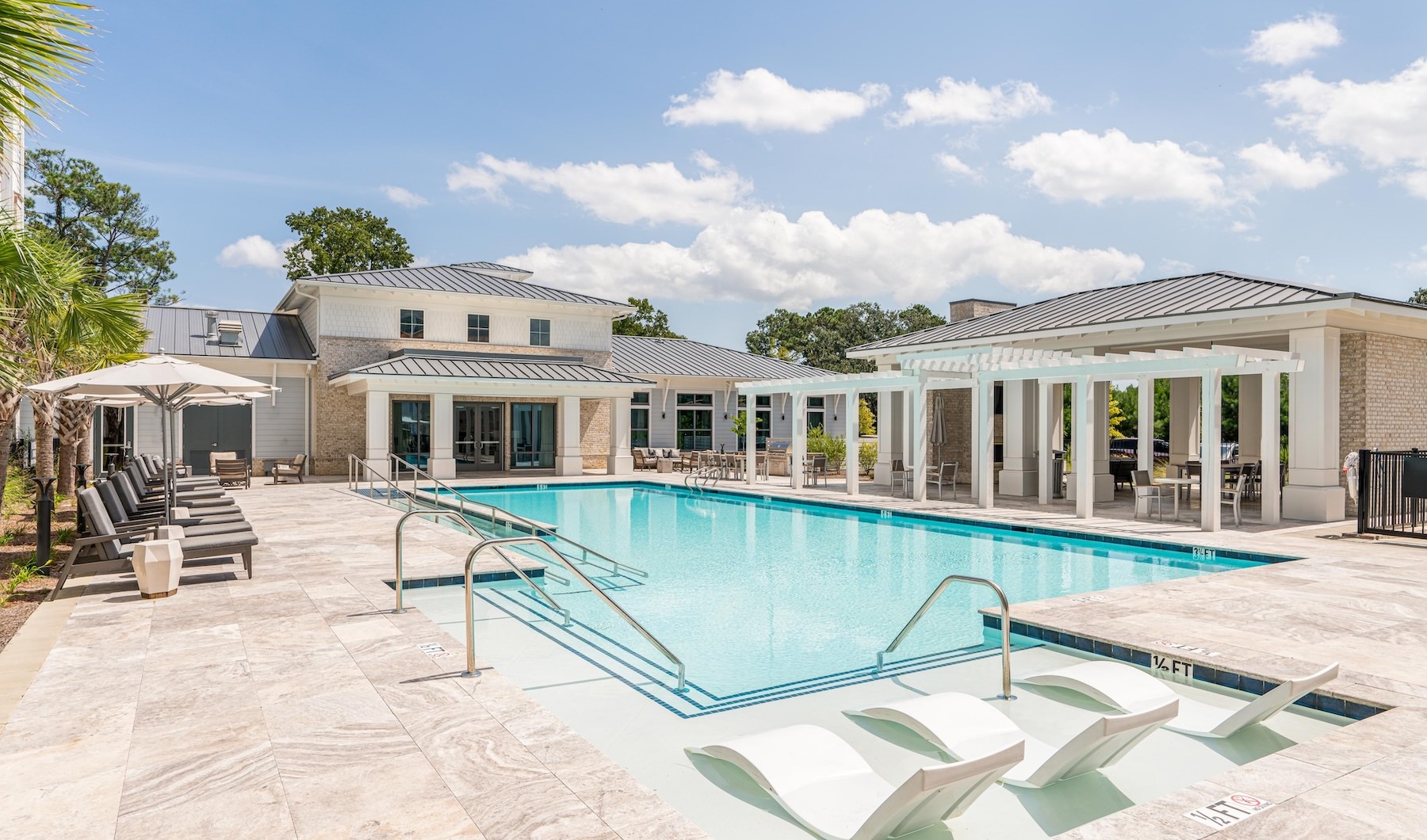 Swimming Pool Large sparkling blue pool with a large deck and lounge chairs