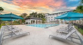 a pool with umbrella shaded lounge chairs