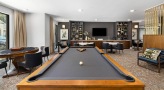 a room with a pool table and chairs