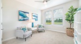 carpeted room with chairs and large windows