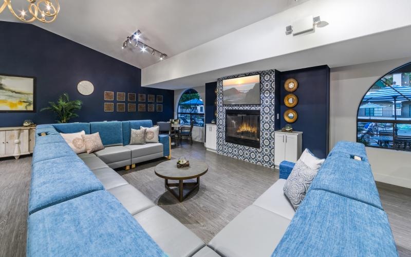 a large social with blue couches and fire place