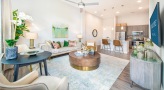 Spacious and well lit living room with wood floors and a large window