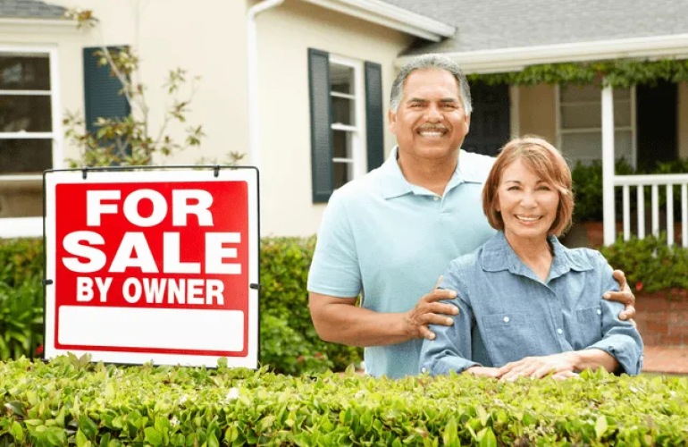 A senior adult couple standing on front of their home with a 