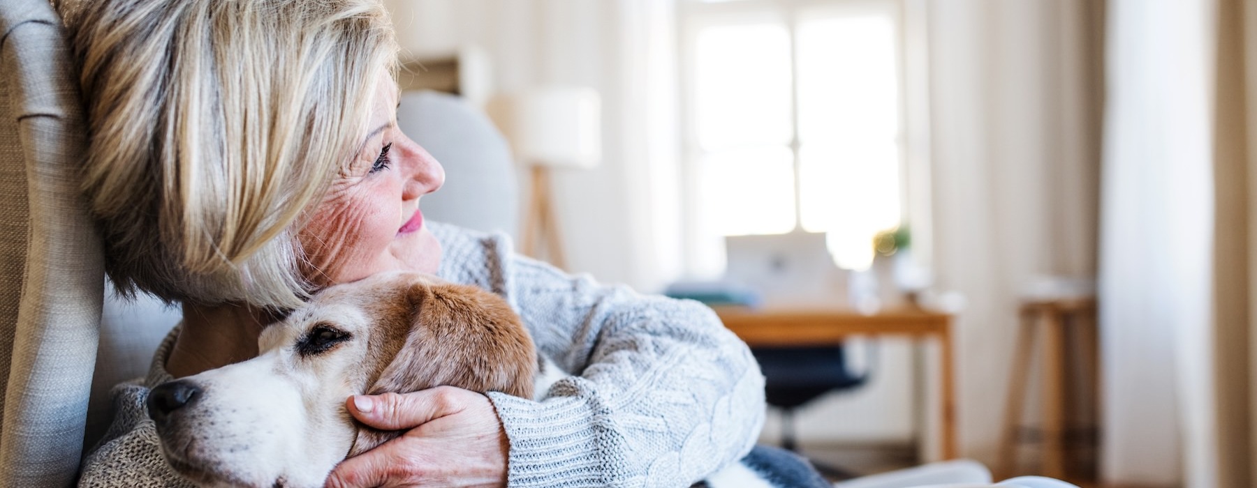 a woman sitting on a couch with her dog