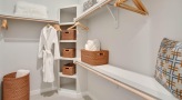 well lit walk-in closet with shelving