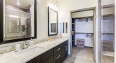 walk-in shower and closet in bright bathroom