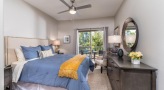 Large well lit bedroom with carpeted floors and a large window 