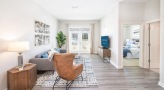 Spacious and well lit living room with wood floors and a large window