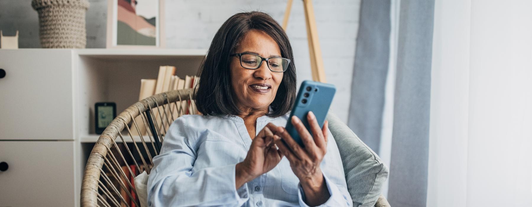 a woman sitting in a chair looking at a phone