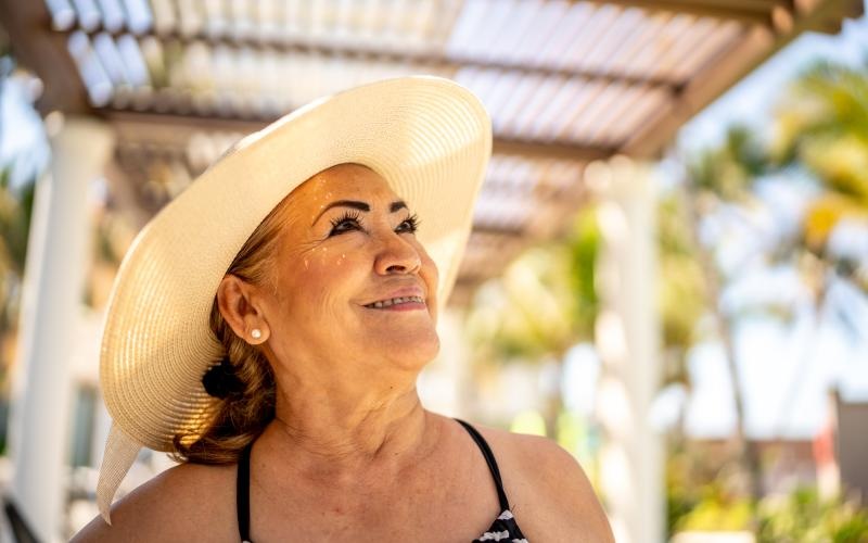 Woman standing by the pool smiling 