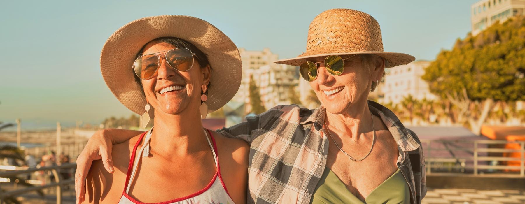 two women walking outside with sun hats on