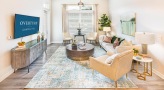 Spacious and well lit living room with wood floors and a large window