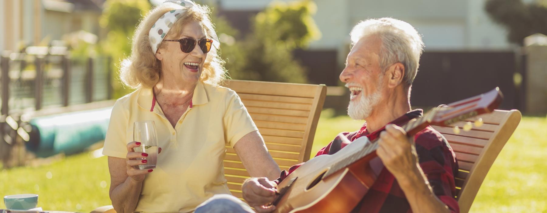 Couple outside playin guitar and smiling 