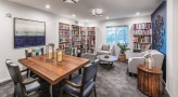 a room with a table, chairs, and book shelves