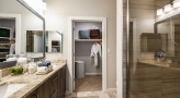 large bathroom with brown accents and closet space