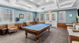 a room with pool tables and chairs