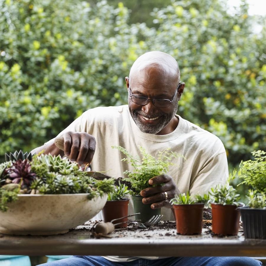 a man sitting at a table working with flowers