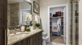 Large well lit bathroom with brown accents 