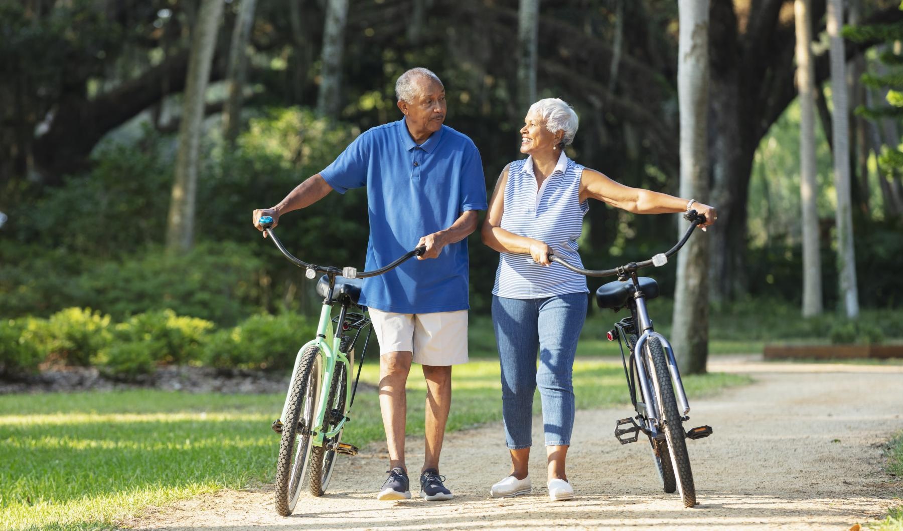 Your Story to Create a man and woman walking their bicycles through the park