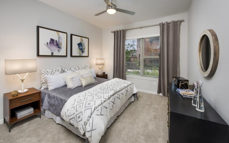 a bedroom with a ceiling fan and light fixture