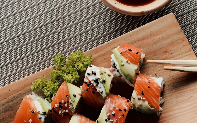 Sushi On Japanese Restaurant sushi rolls and chopsticks on a wooden plank