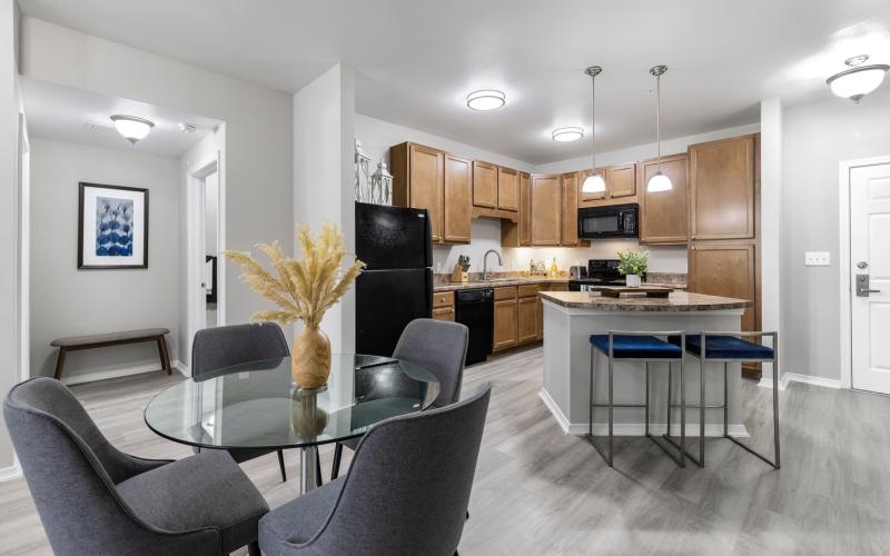 Spacious and well lit kitchen with wood floors and stainless steel appliances