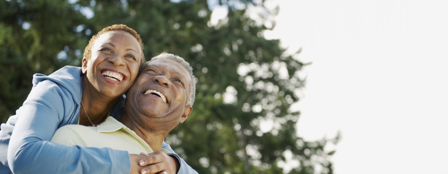 a man and a woman hugging outside and smiling