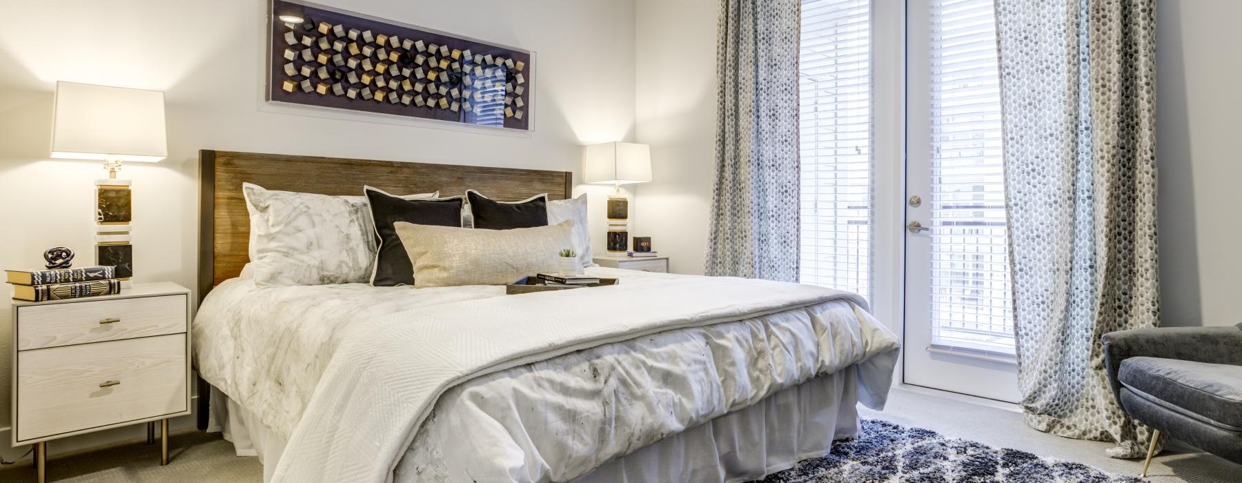 Large well lit bedroom with carpets and a large window