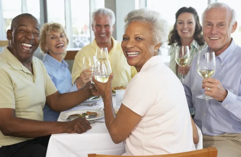 Senior couples enjoying wine around a table.