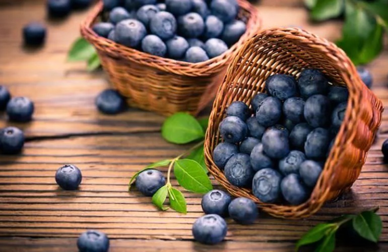 Grapes in small baskets sitting on a table.