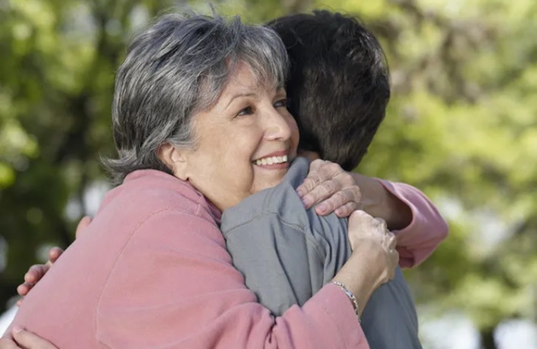 Senior adult woman hugging her grandchild.