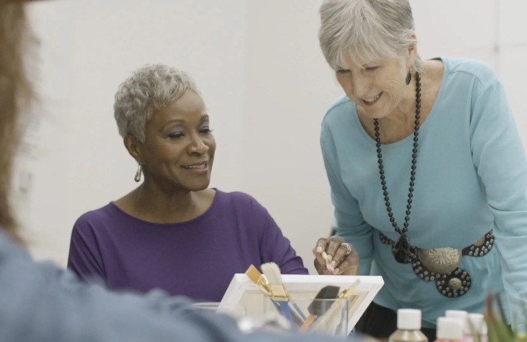 Senior adult women painting in a class.