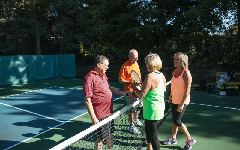 a group of people standing on a Pickleball court