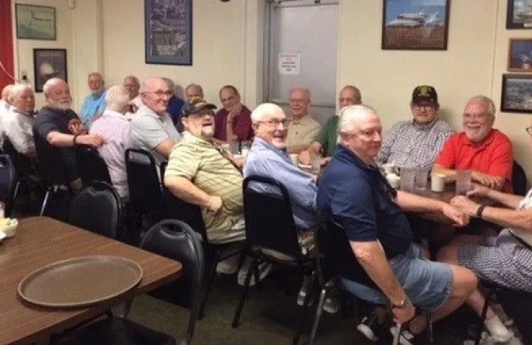 A group of senior adult men having breakfast at a restaurant.