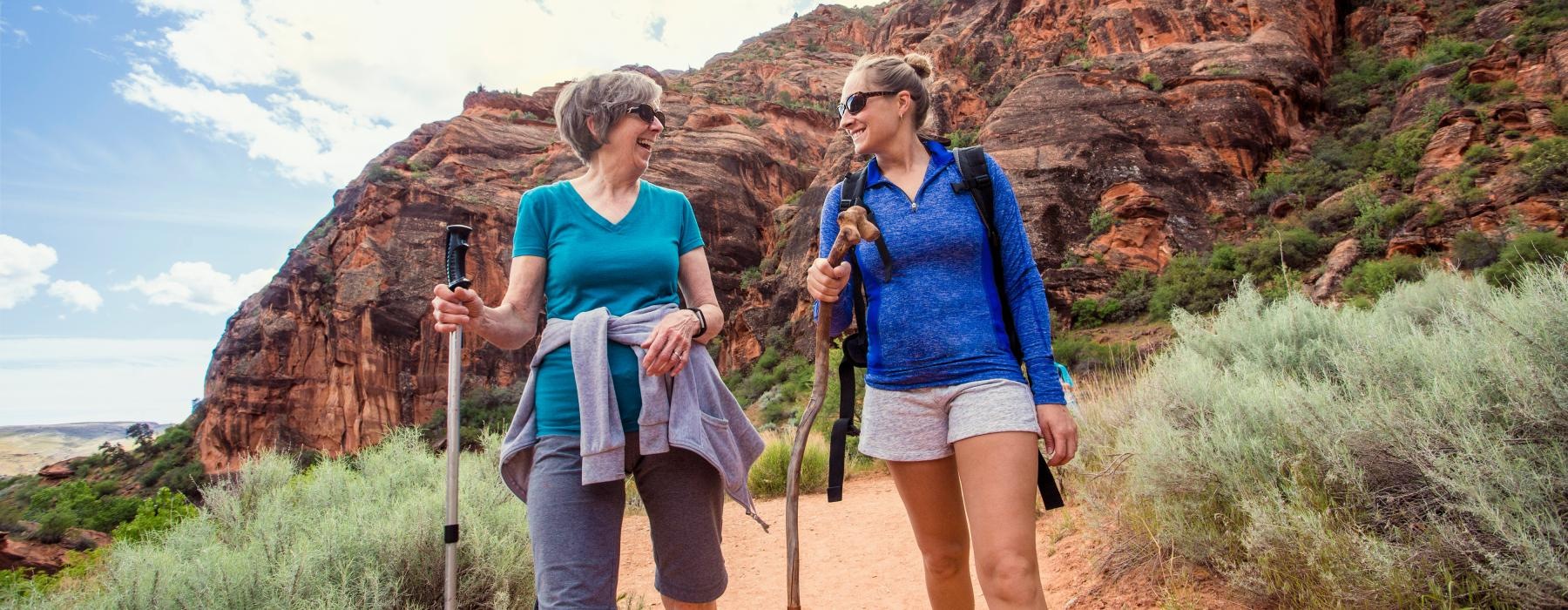 two women hiking with mountains behind them