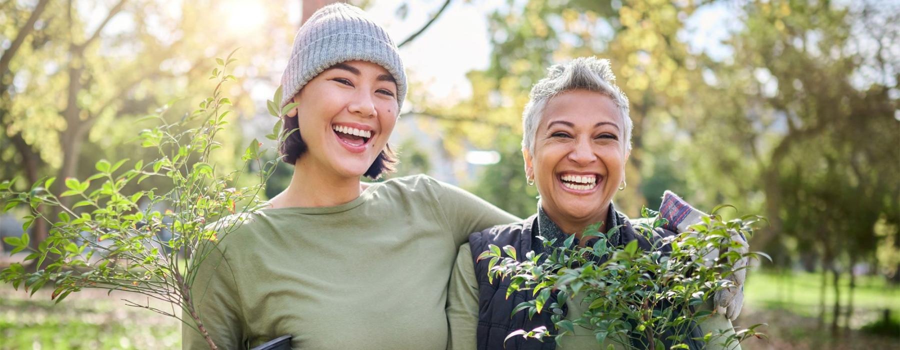 Friends standing outside holding flowers smiling