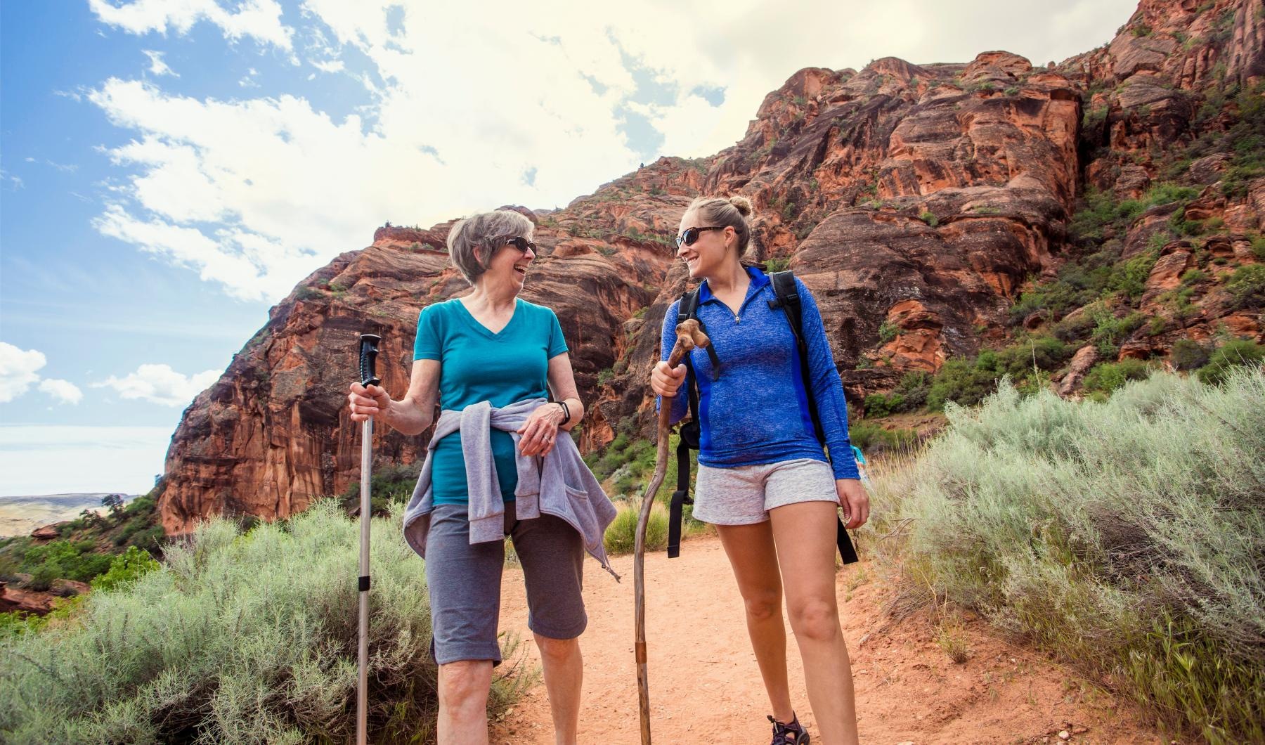 two women hiking with mountains in the background