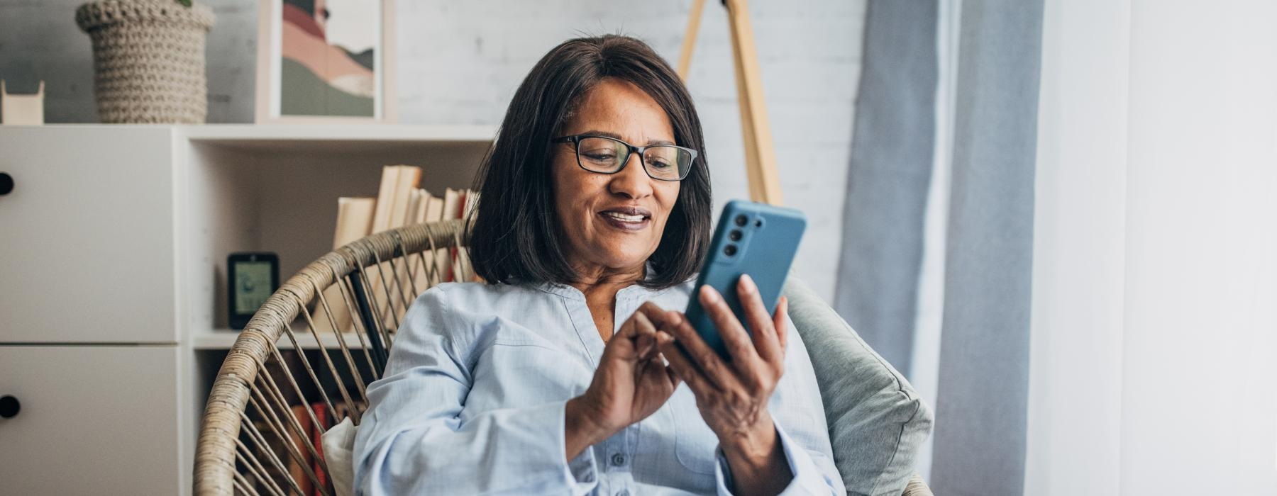 a woman sitting in a chair and holding a phone