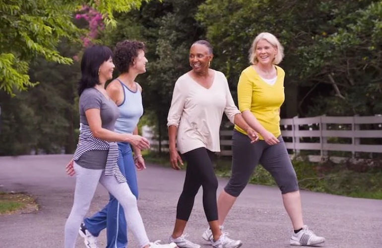 Senior adult women walking in a park.