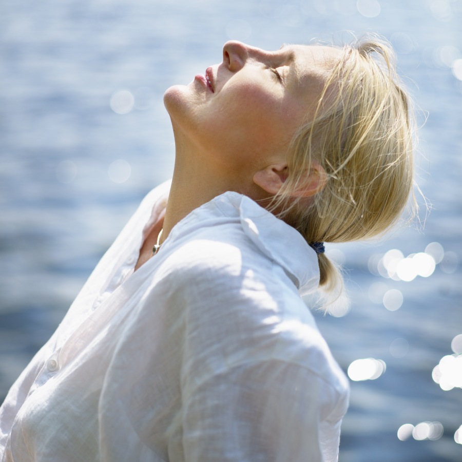 woman looking up with water in the background