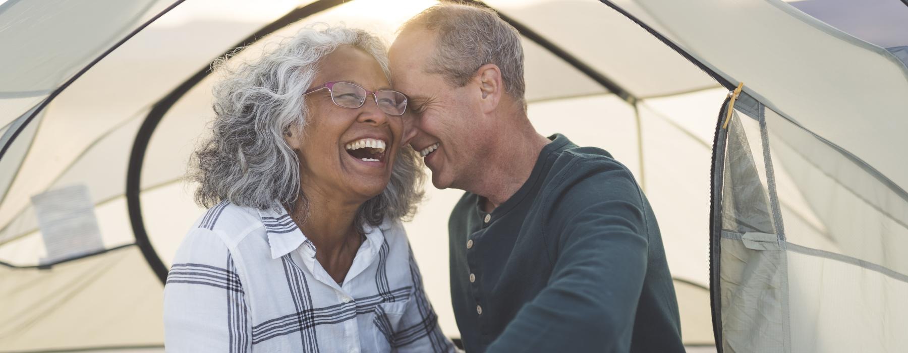 Couple relaxing in a tent laughing 