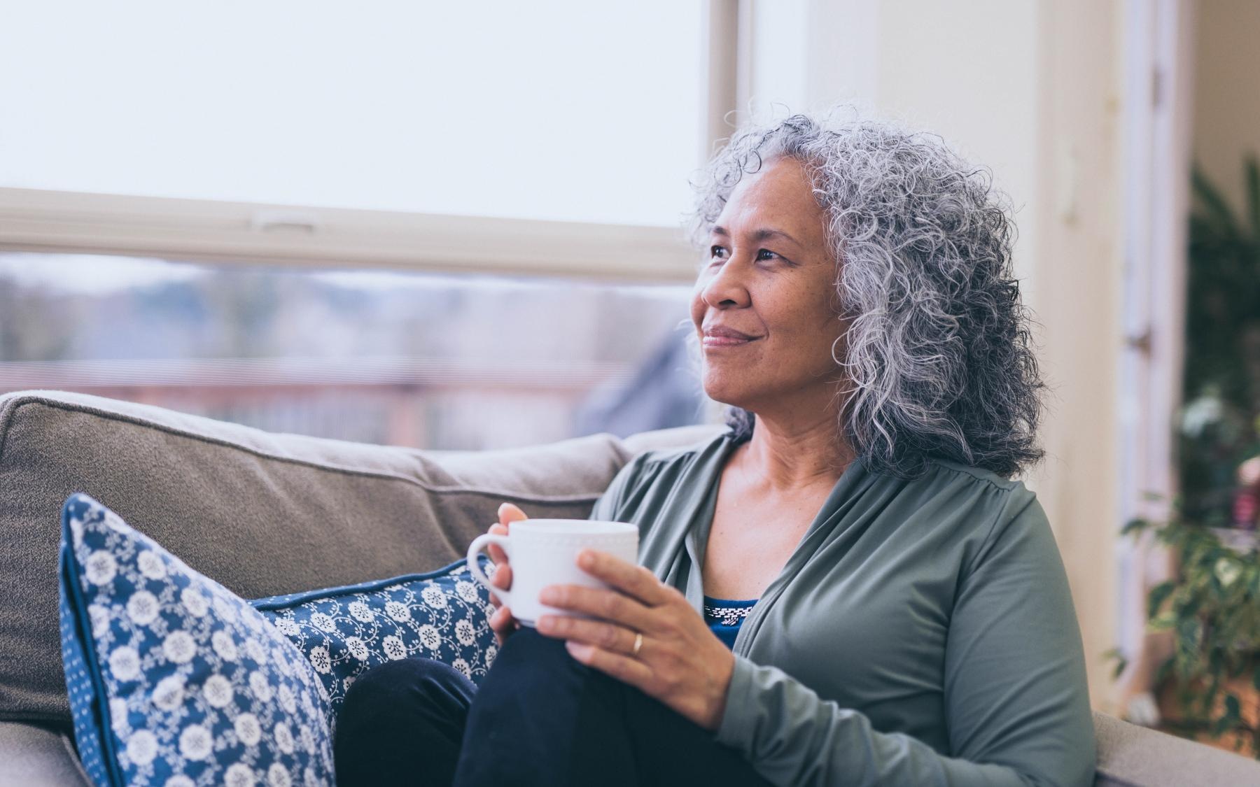 Lifestyle Woman sitting on a couch drinking coffee