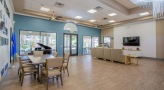 a room with a large tv, chairs and tables