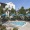 swimming pool in a courtyard with trees and umbrellas around it