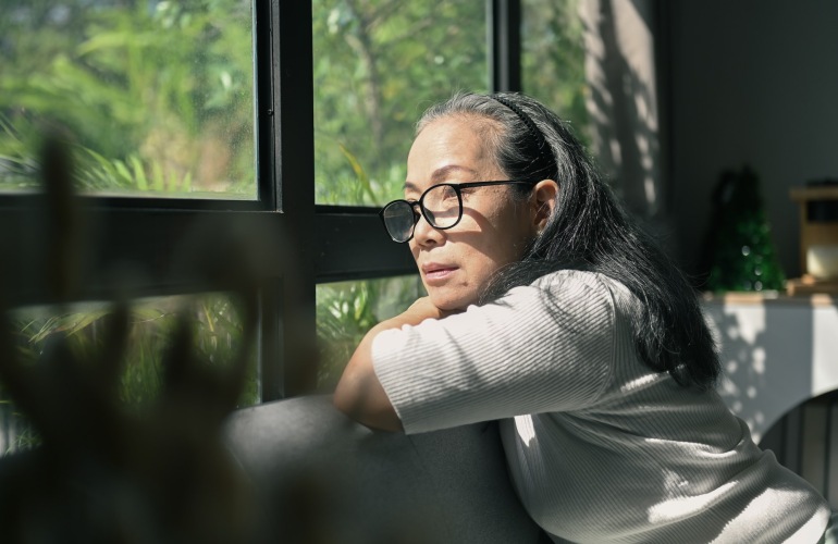 a person leaning on a couch looking out a window