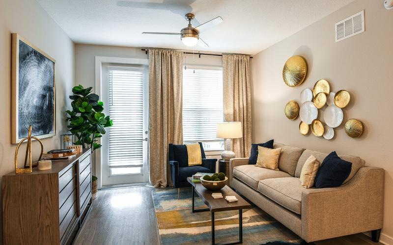 Spacious and well lit living room with wood floors and large windows 