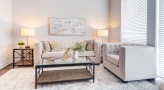 Spacious and well lit living room with wood floors and a large window