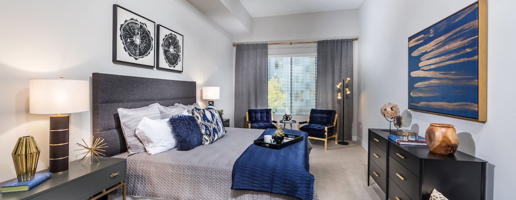 bedroom with a large window and art on the wall