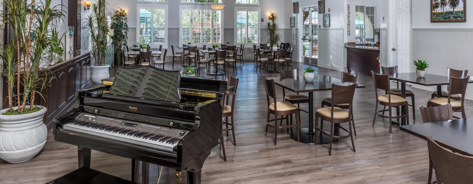 a room with a piano and seating areas