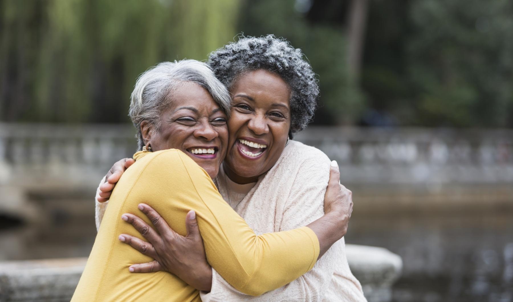 Your Joy to Embrace two women hugging each other with a pond in the background